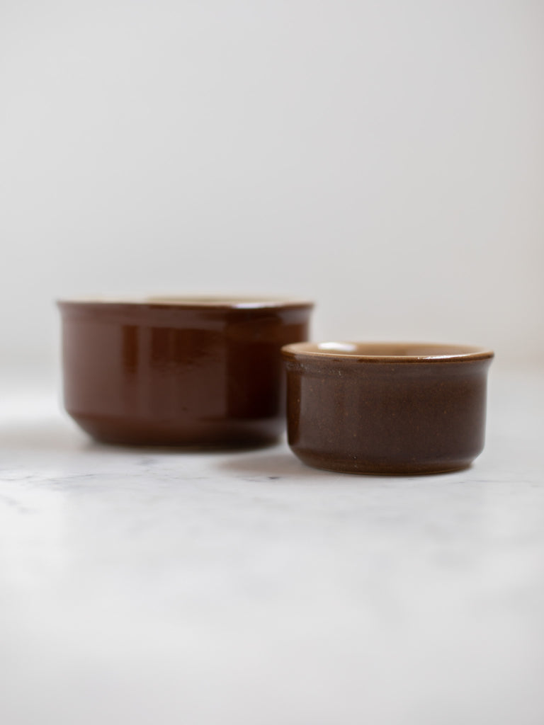 Dark brown bowl dish with a smaller one beside it. 