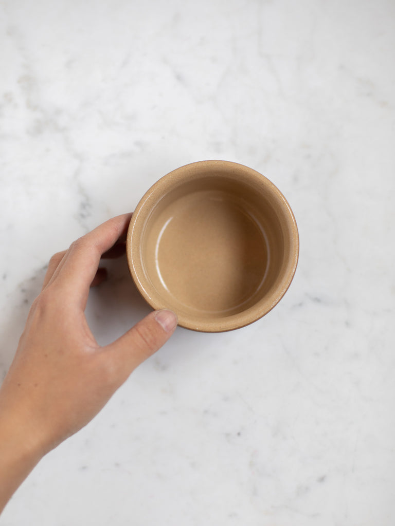 Dark brown bowl dish from the top, light brown interior. 