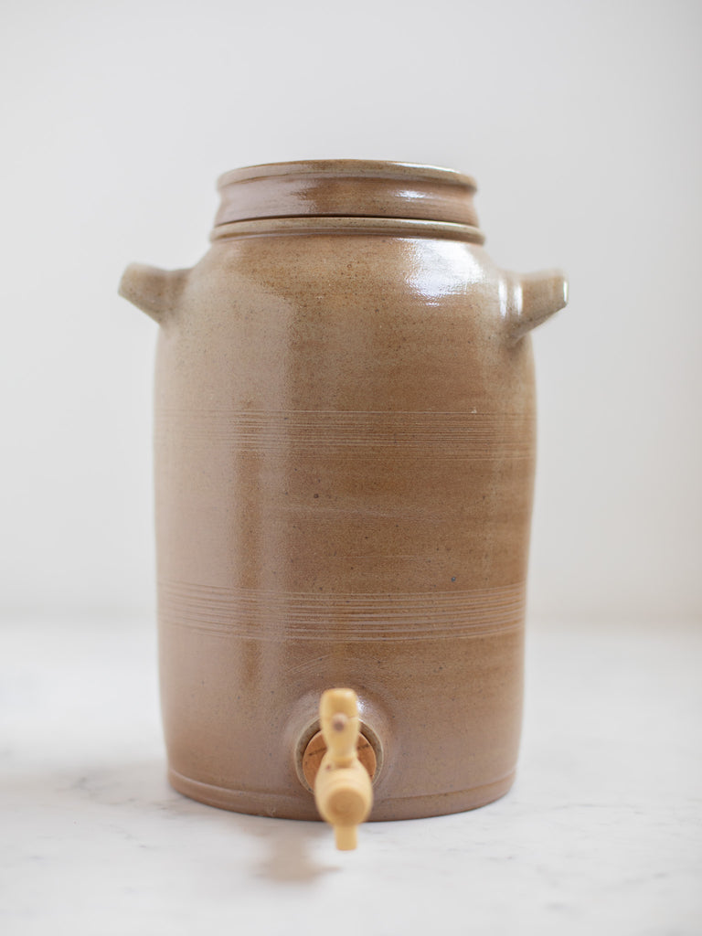 Tall brown water jug with built in handles. 