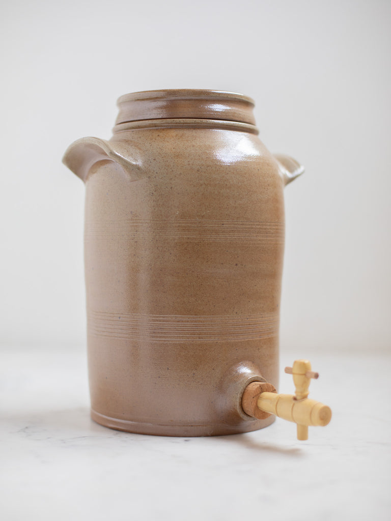 Tall brown water jug with built in handles.