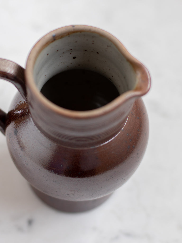 Dark brown pitcher from the top showing speckled interior. 
