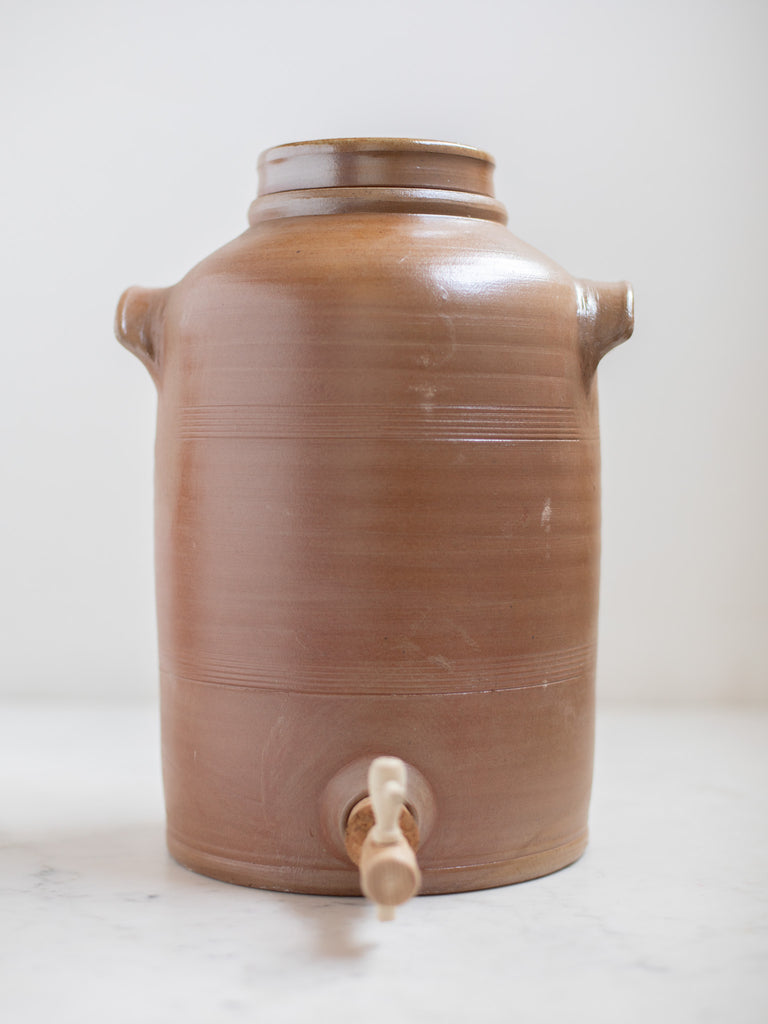 Large light brown water pitcher with built in handles. 