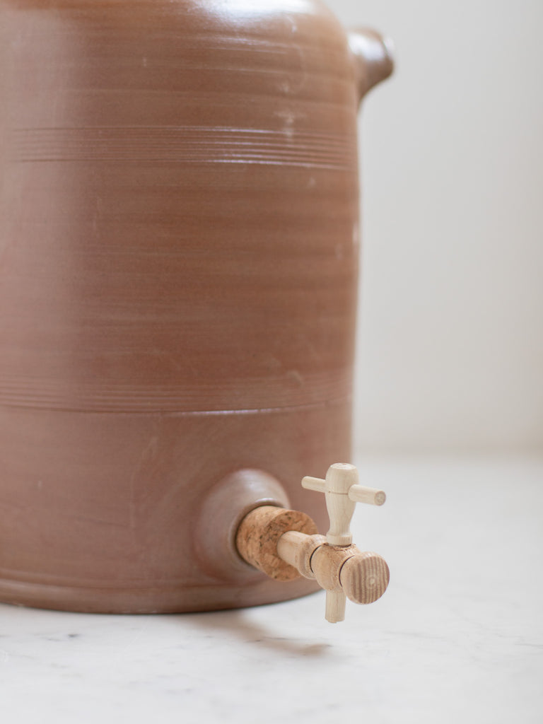 Spout on a brown water pitcher. 