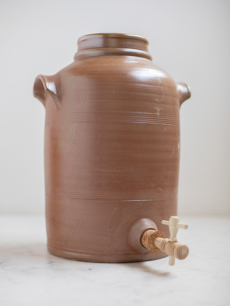Large light brown water pitcher with built in handles. 
