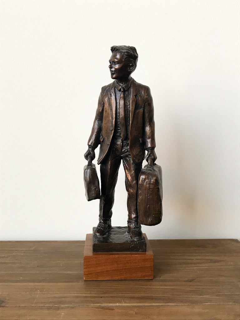 Bronze statue of man with suitcase and briefcase