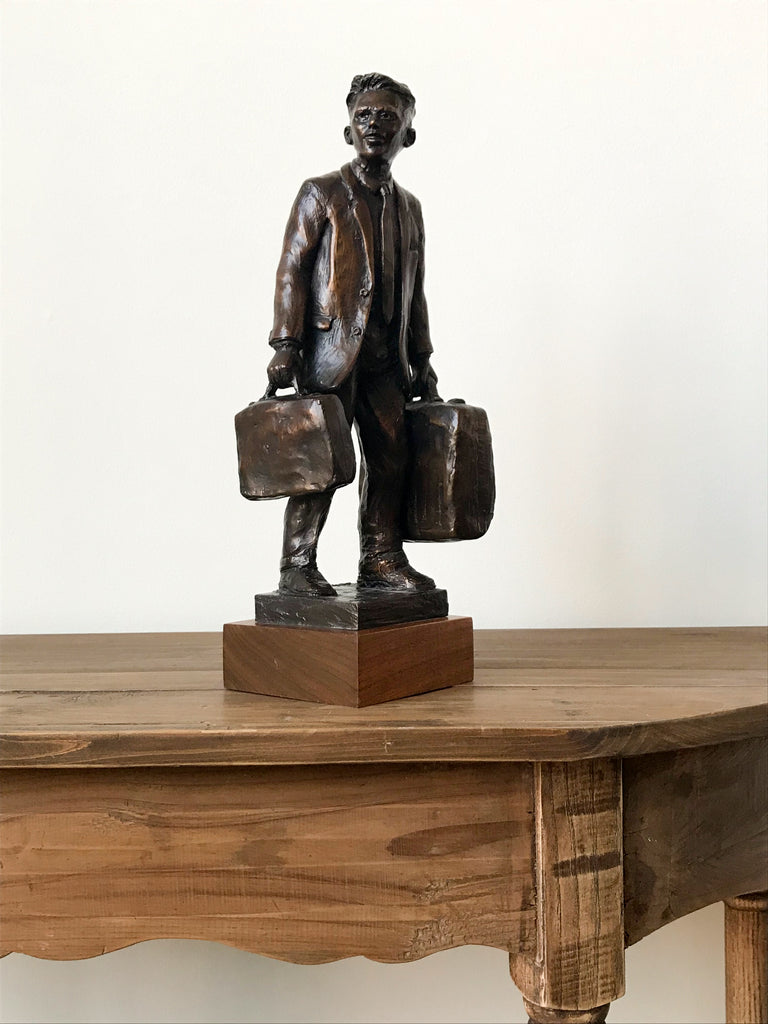 Bronze statue of man with suitcase and briefcase