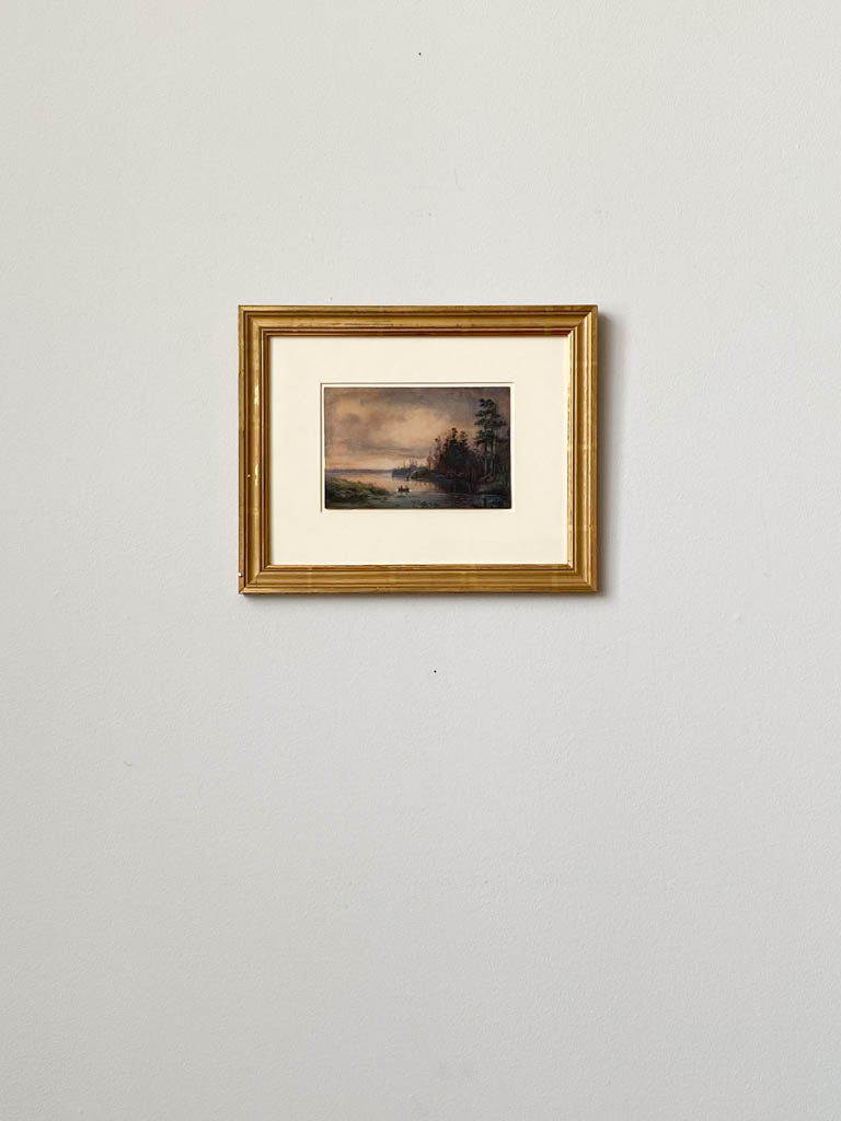 Evening River Landscape, painting depicting two people in a small boat in the woods at dusk. Painting framed in gold and hung on a wall. 