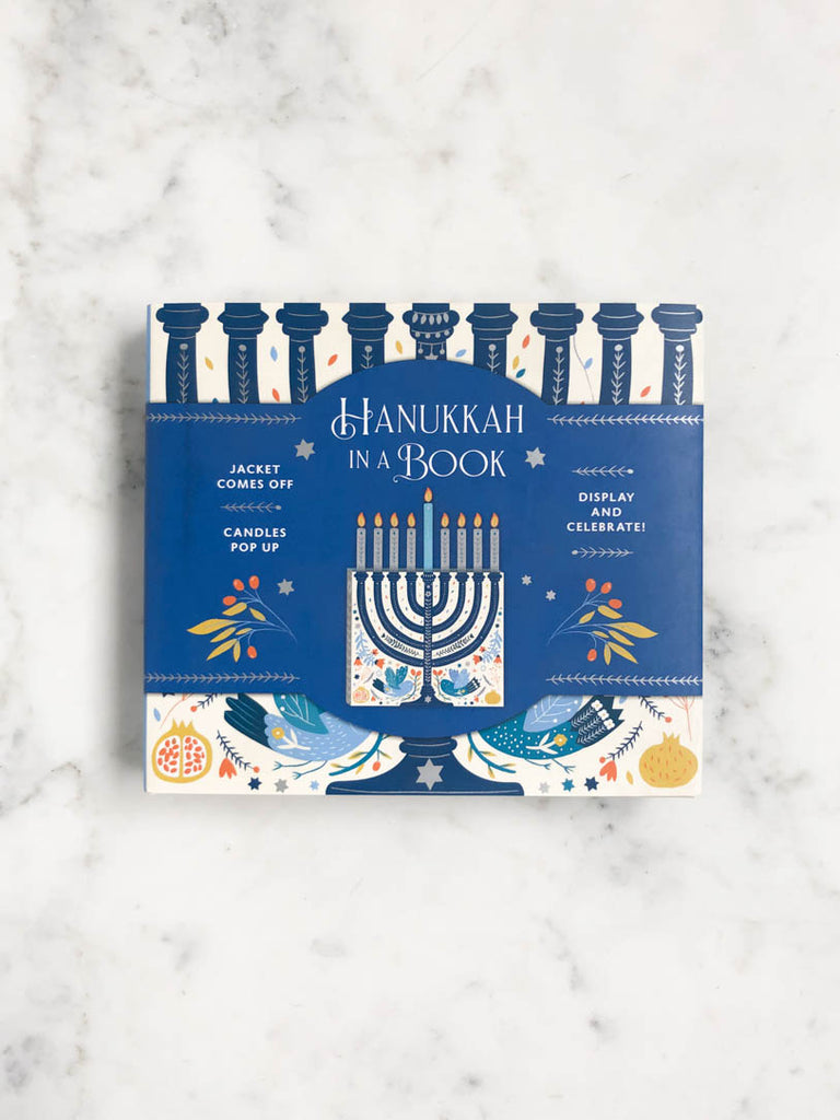The cover of the book with a large blue black displaying the title and picture a blue drawn menorah.
