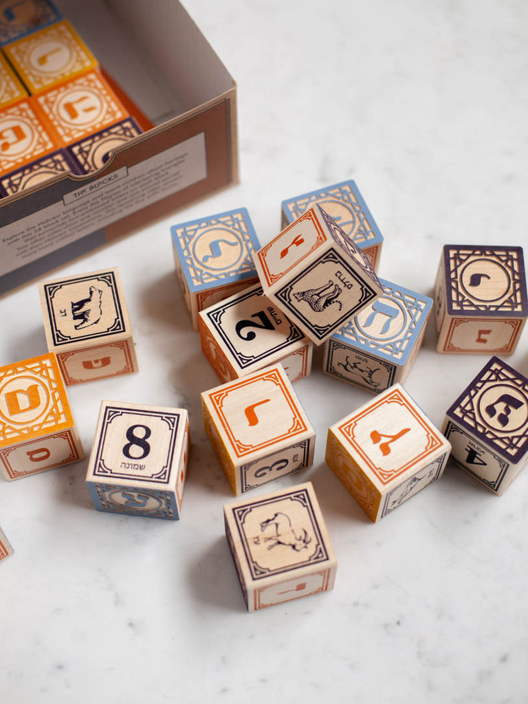 Blocks with symbols and animals on them scattered by a box containing more of them.