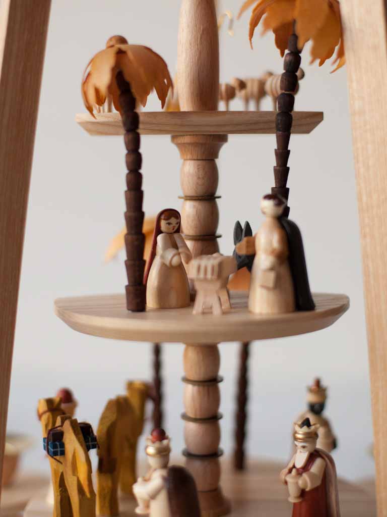 Close up view of the Holy Family. Wooden Mary stands over the cradle of Jesus.