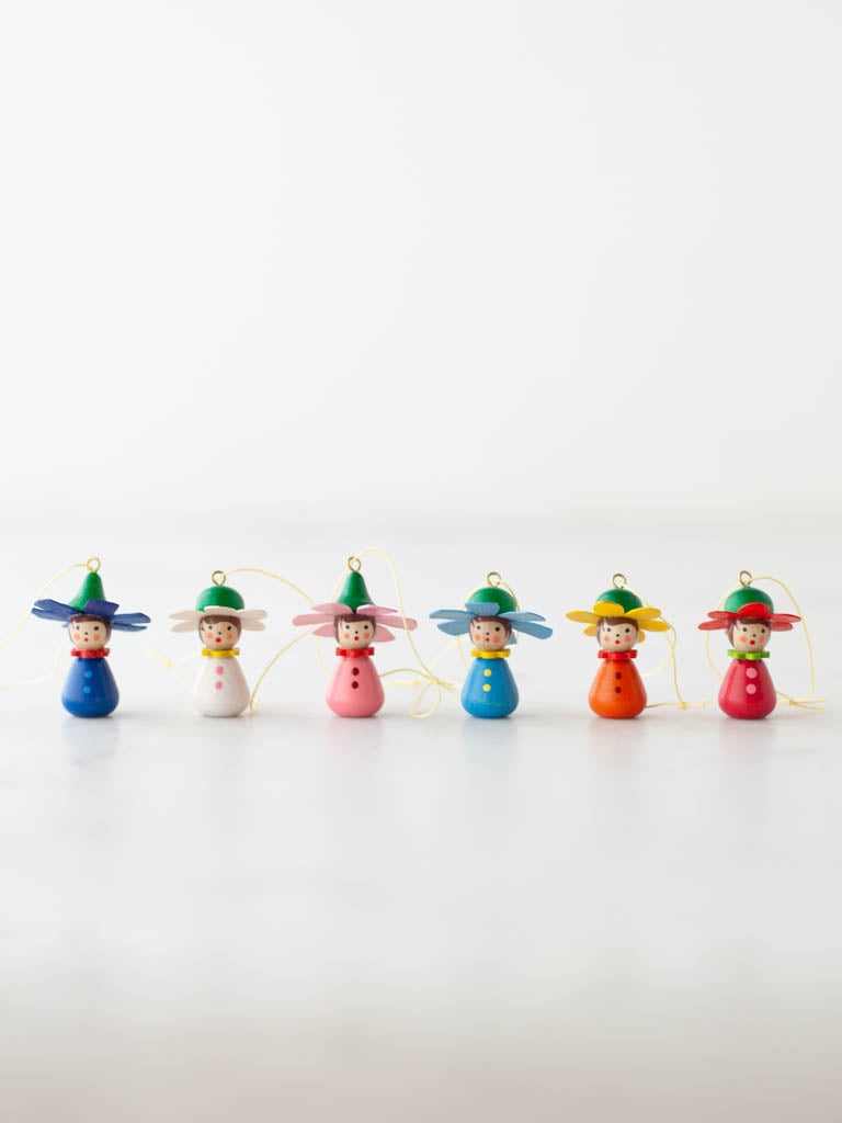 Colorful hanging Flower Children with hats and button ups lined up together. 