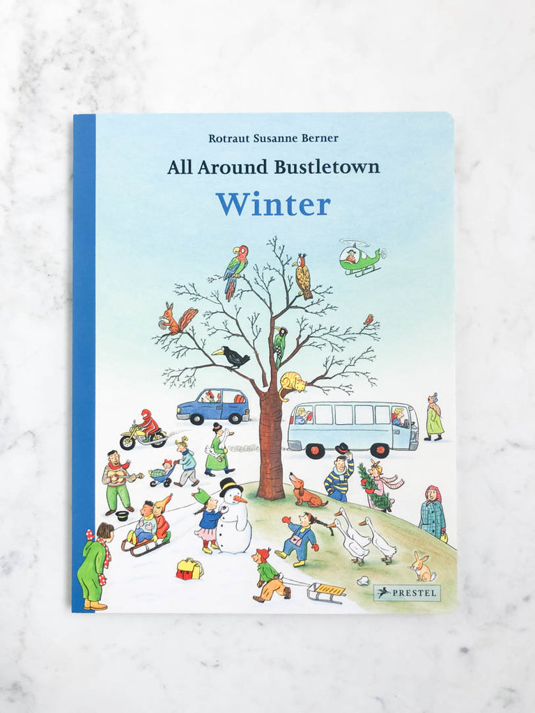 Front view of a blue book cover entitled “Winter’”. The cover illustrations show birds in a leafless tree surrounded by kids doing winter activities.