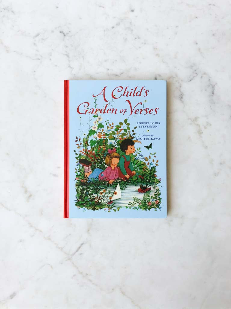 A Child’s Garden Verses cover of a little boy and girl sitting outside in the grass next to a stream of water.