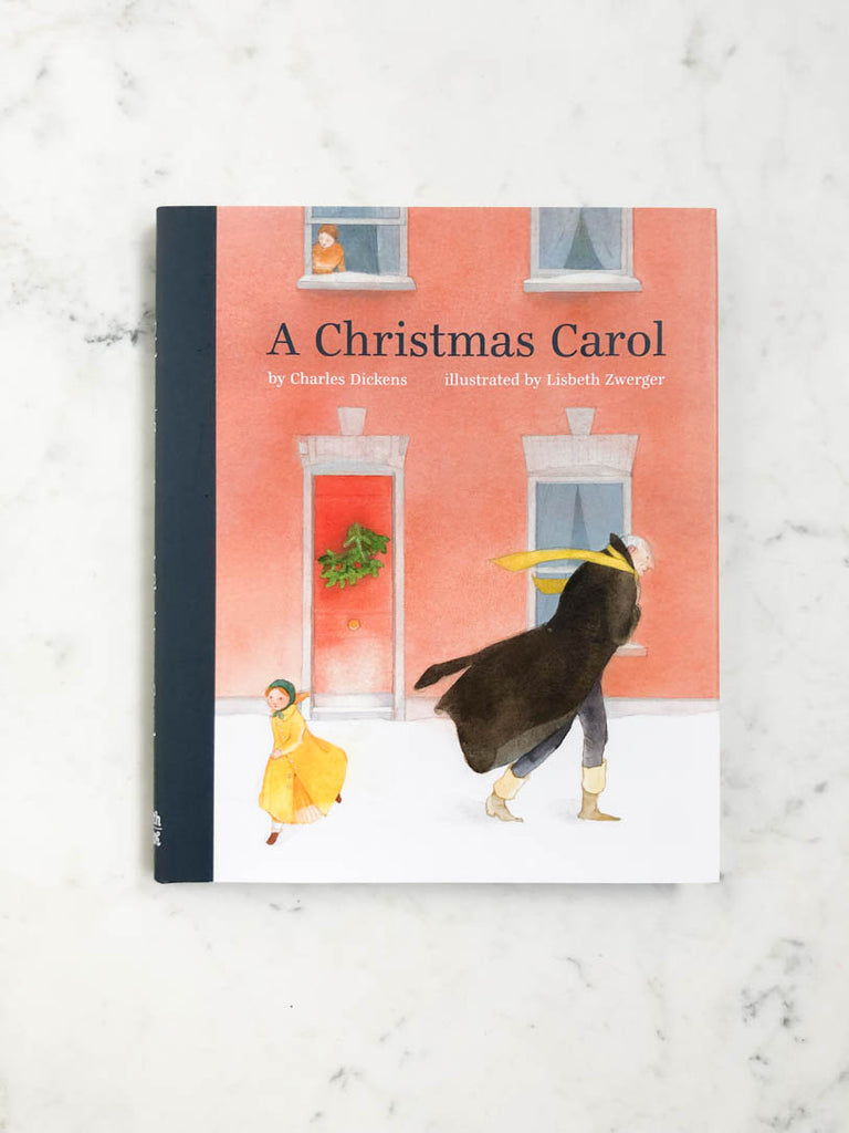 A Christmas Carol lays flat in full view. A man in large cloak walks through the village with the wind blowing into him as a child runs always. 