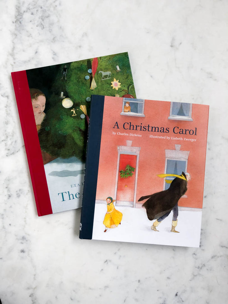 A Christmas Carol book lays on top of another book.