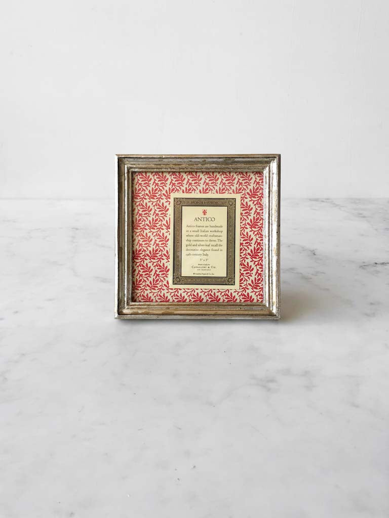 Vintage style silver frames, with a dark red patterned paper held in the frame, with a description of where the frames are made.