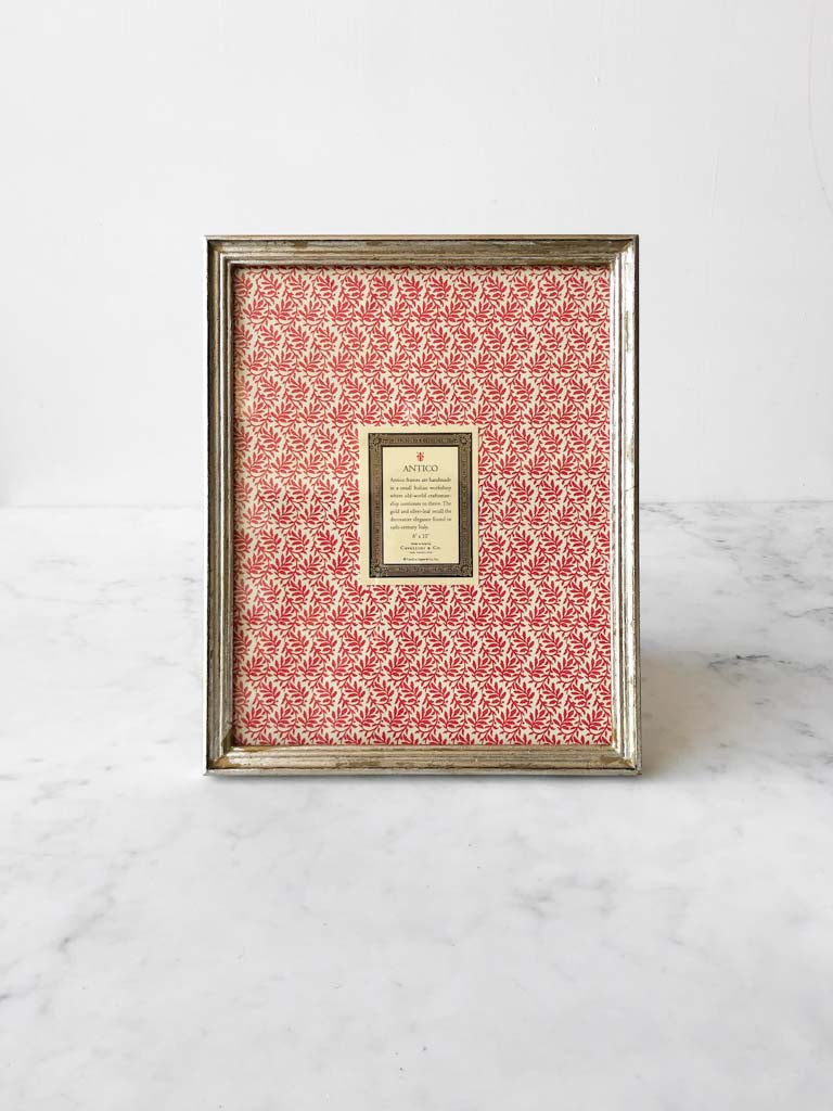 Vintage style silver frames, with a dark red patterned paper held in the frame, with a description of where the frames are made.