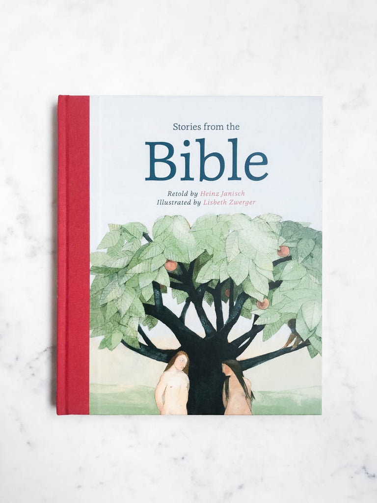 Stories from the Bible book lays flat on a countertop. The cover illustration shows a naked Adam and Eve in front of a large tree with fruit.