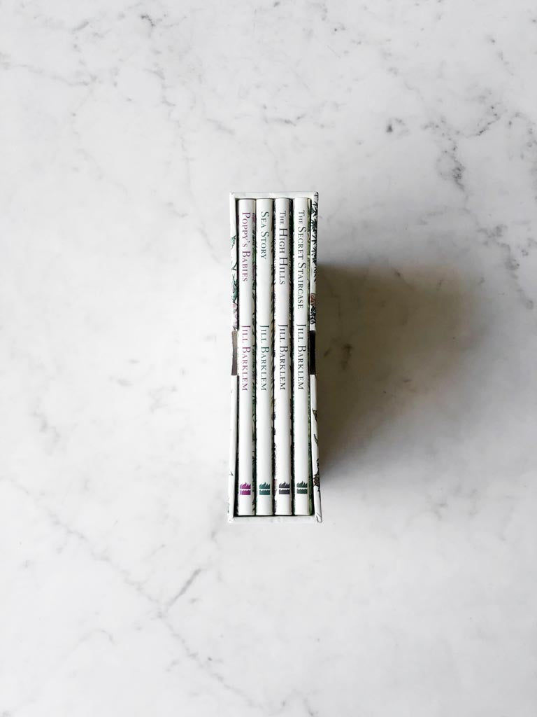 The spines of four brambly hedge books set together inside their box packaging.