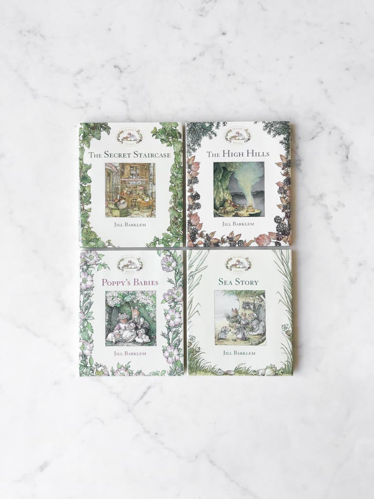 Four brambly hedge collection books laid out next to each other on a white counter.