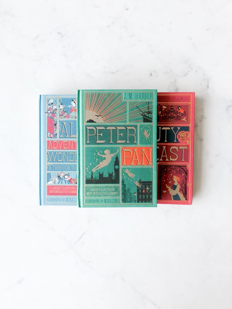The covers of Peter Pan, Beauty and the Beast, and Alice’s Adventures in Wonderland piled on top of one another.