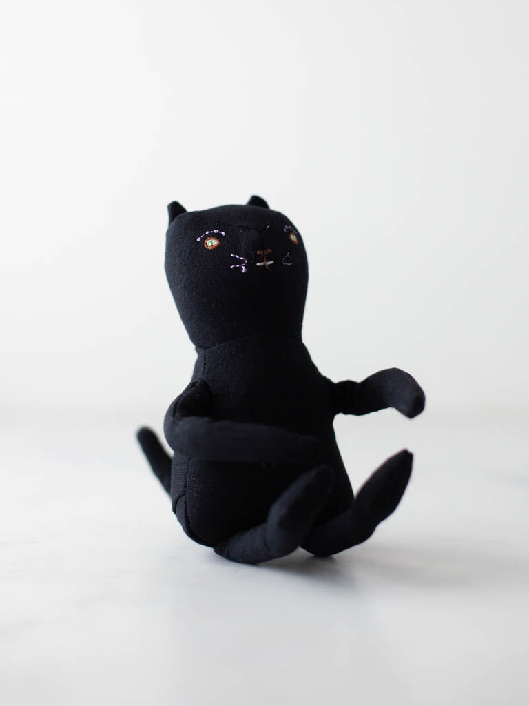 A stuffed cat with embroidered features. 