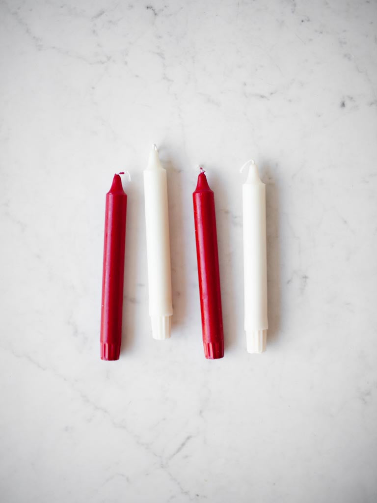 Some red and white candles on a table. 