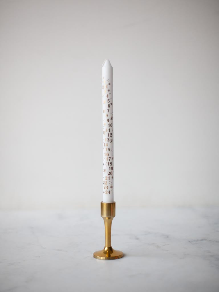 White candle in a brass candle holder