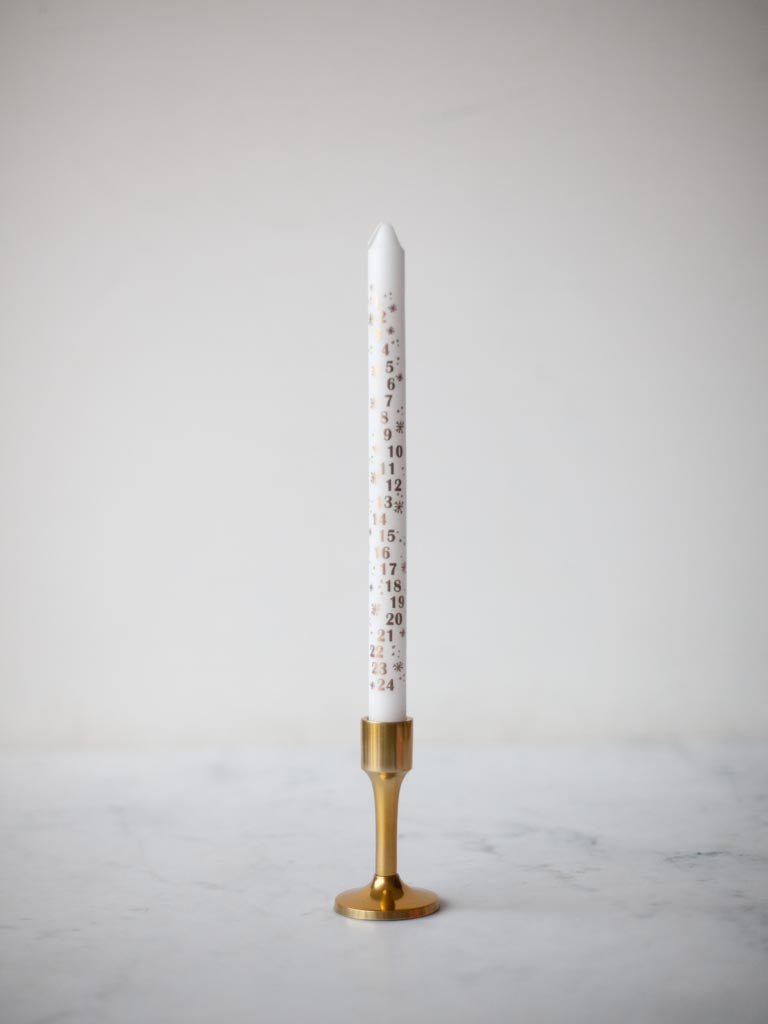White candle in a brass candle holder