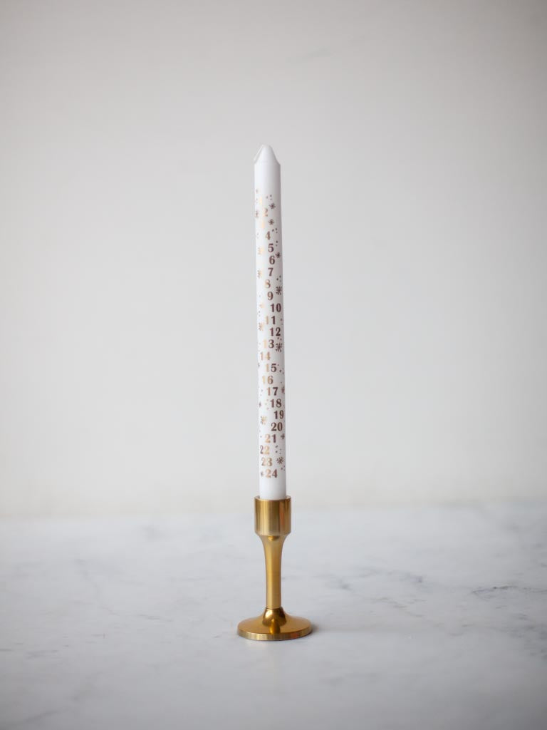 White candle in brass candle holder