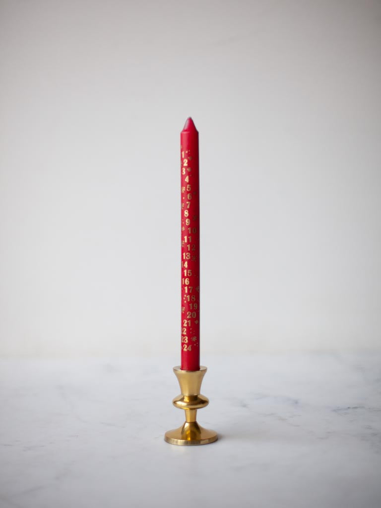 Red candle in a brass candle holder