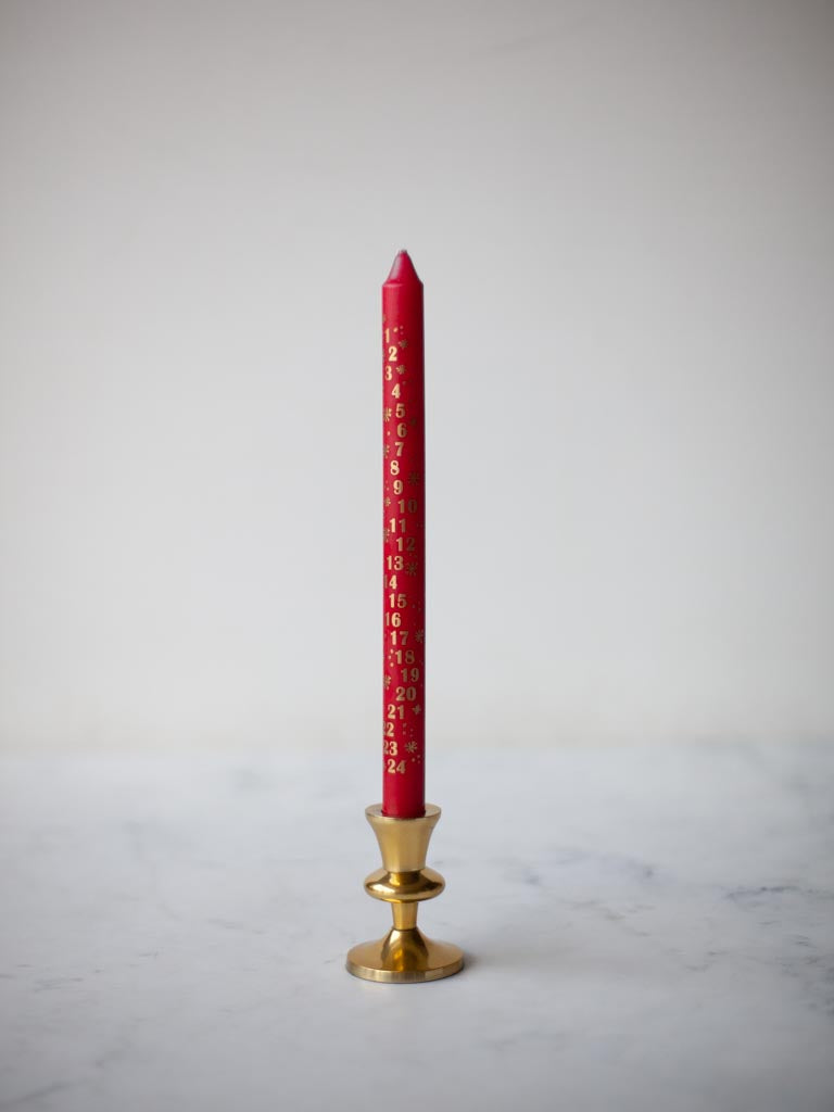 Red candle in brass candle holder