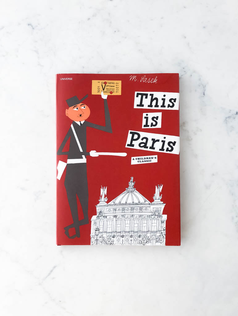 Deep red family friendly book cover labeled as "This is Paris". Image on cover shows man holding a ticket next to an opera house.