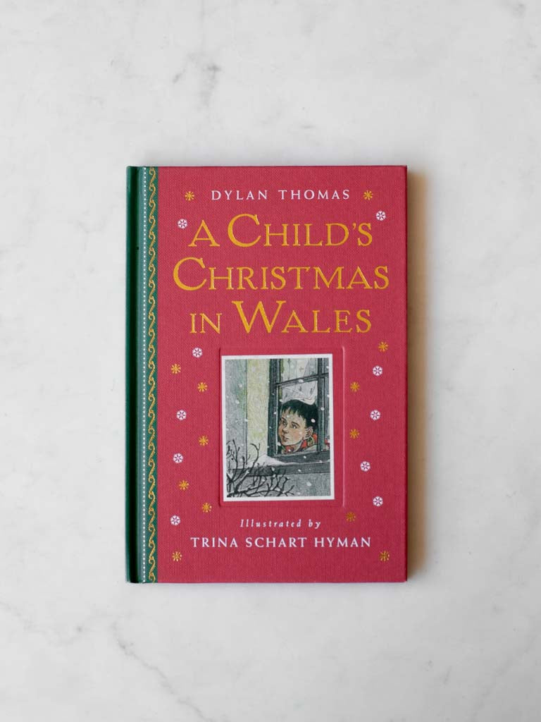 Book cover labeled "A Child's Christmas in Whales" with image of boy looking out a window with snow falling