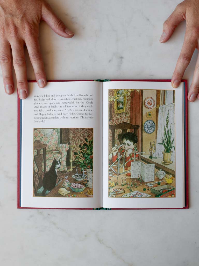 Sample pages of book held open by two hands