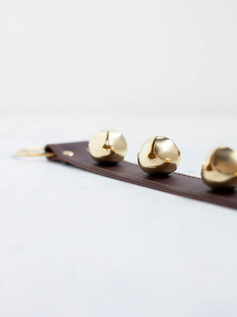 Up close photo of the bells on the strap and the gold hoop. 