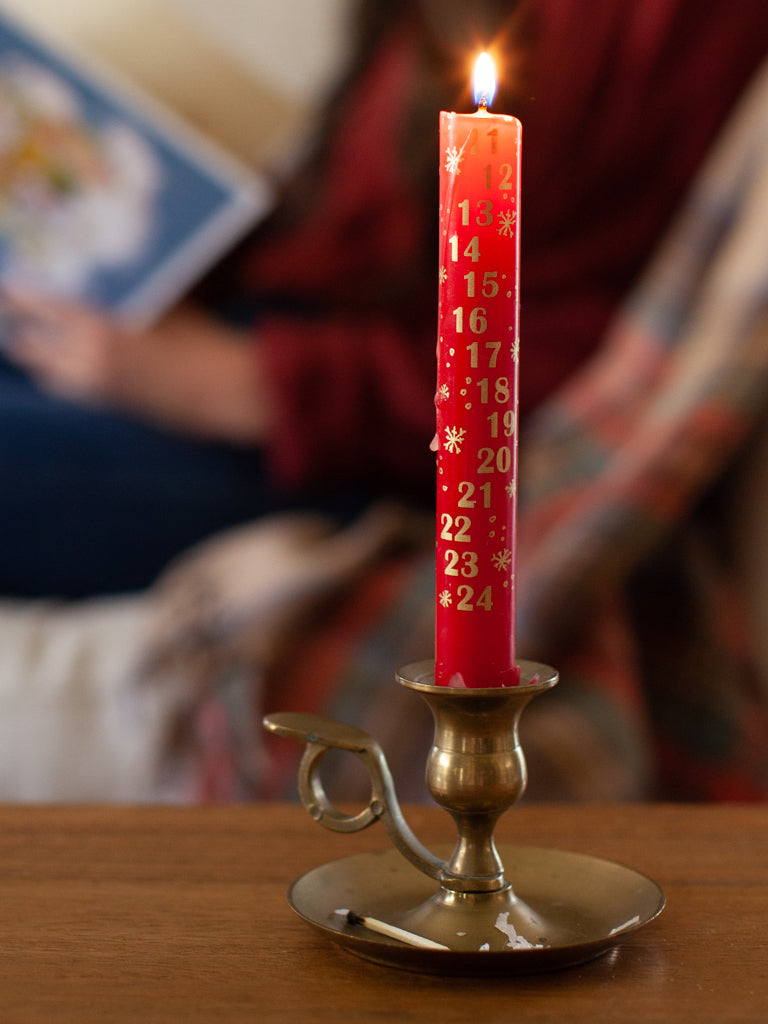 Red advent candle burning showing the advent practice.