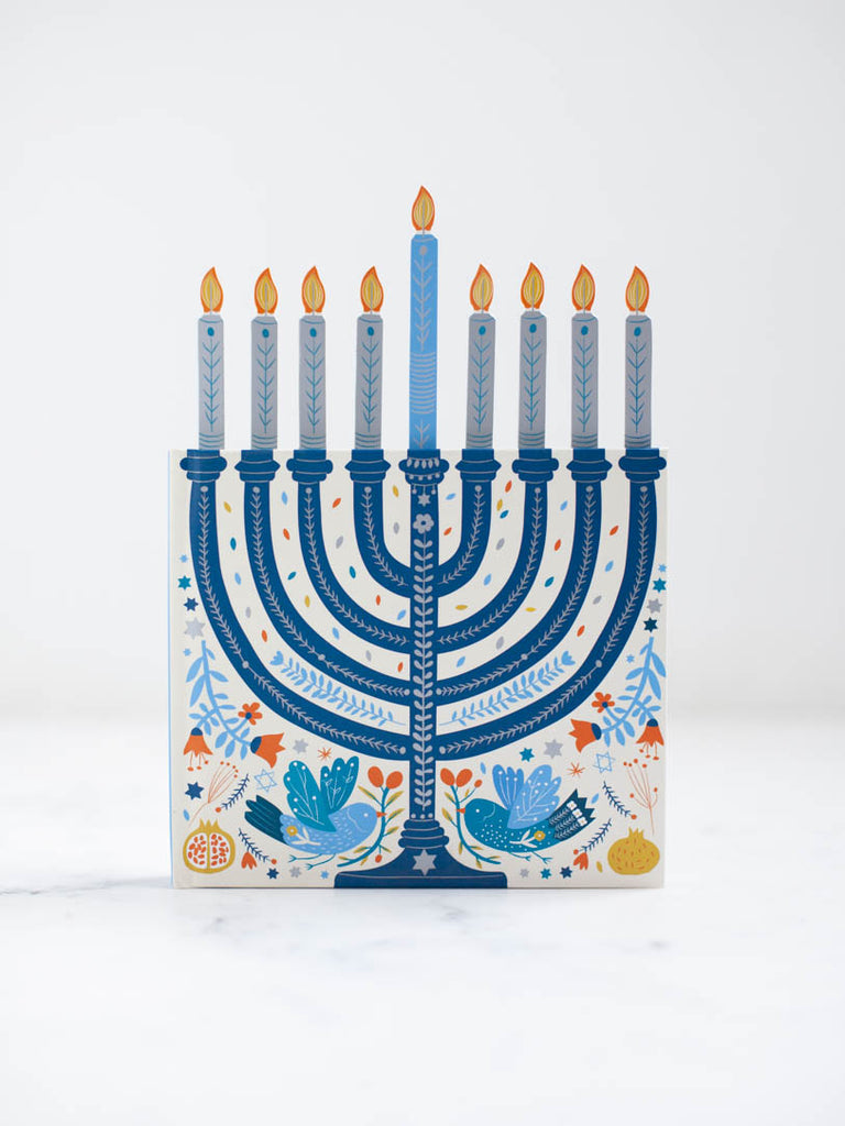 Part of the book displaying a drawn blue menorah with all of its candles lit.