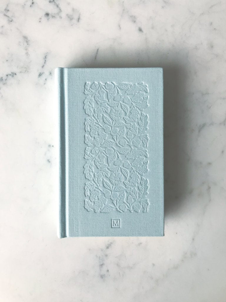 Book cover without protective wrap, showing a baby blue cloth cover with a foliage pattern